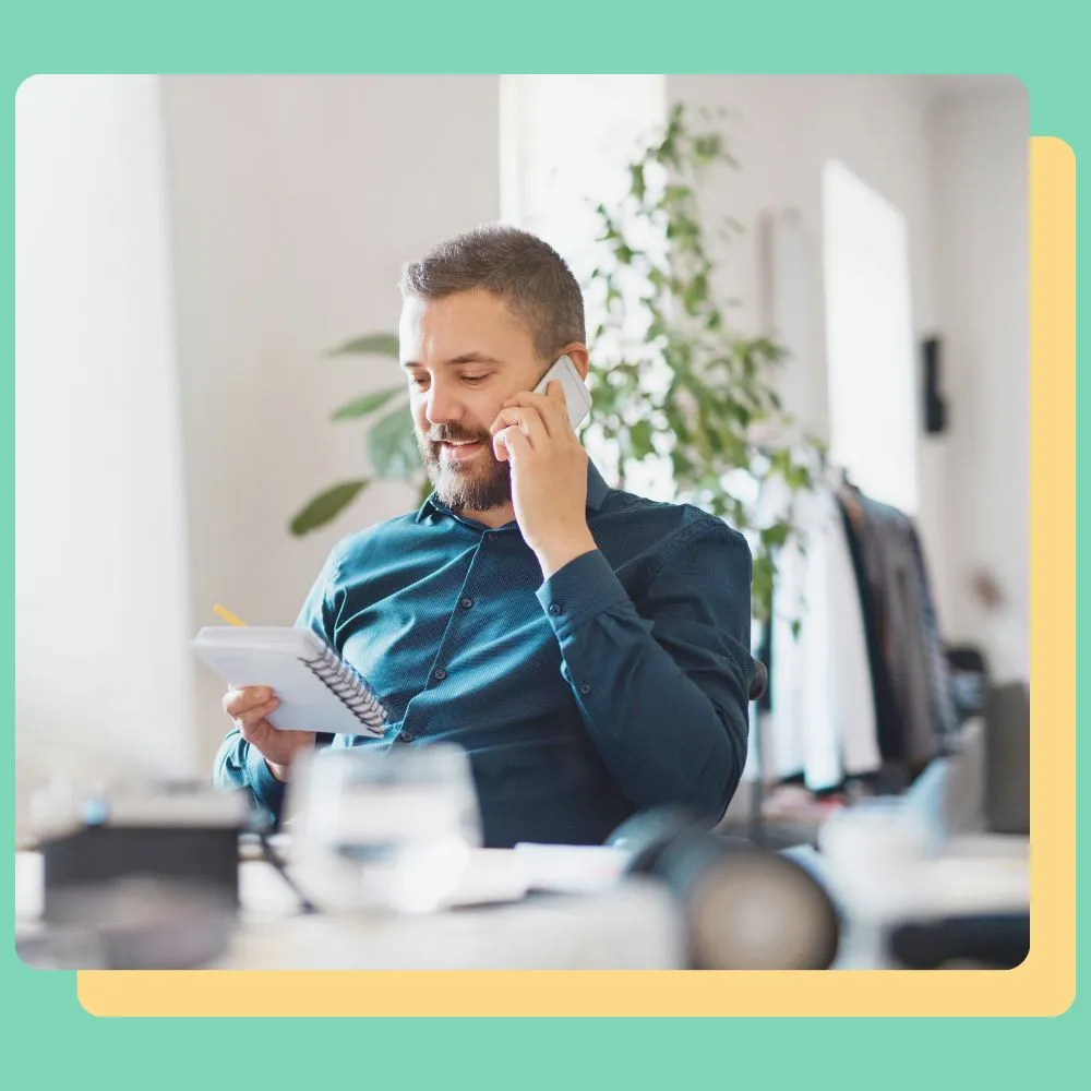 A professional on a phone call in an office, representing cross-border employment services.