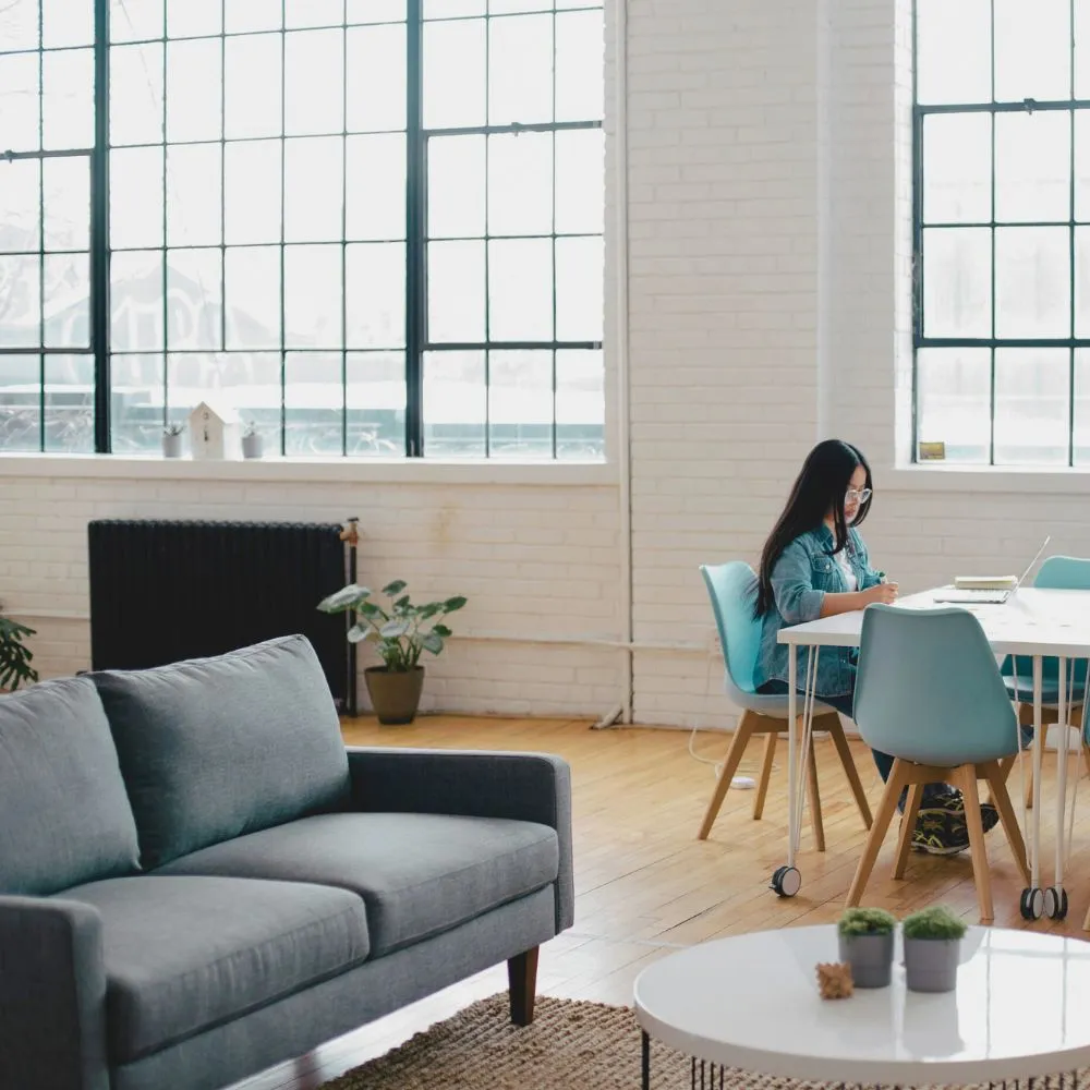 A modern, bright office space with a person working at a table, representing a professional and welcoming environment aligned with core values like integrity, humility, and service.